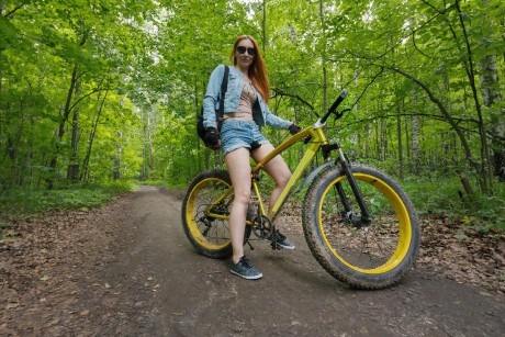 beautiful-girl-shorts-glasses-yellow-bicycle-summer-park_274719-1255